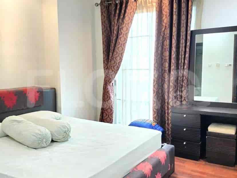 Kamar tidur dengan tempat tidur, meja rias, dan jendela dengan gorden bermotif.