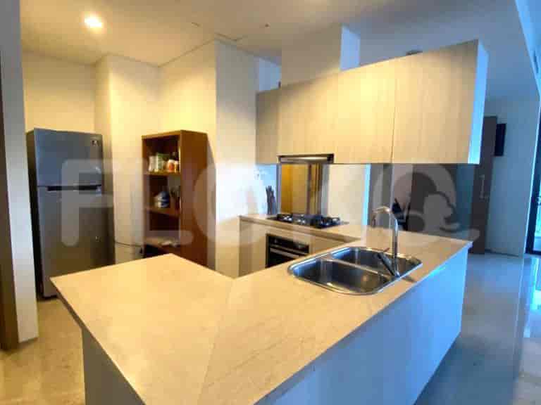 Dapur modern dengan lemari, lemari es stainless steel, dan meja.