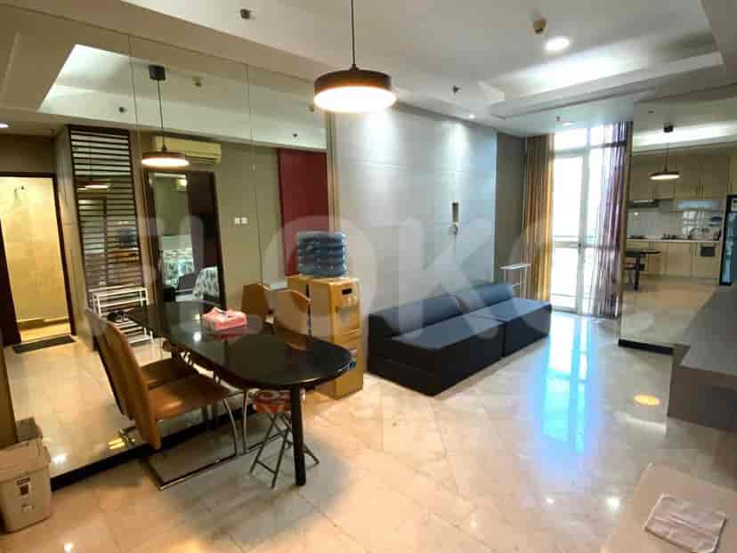 A combined living and dining area with a black dining table, grey sofa, and marble flooring.