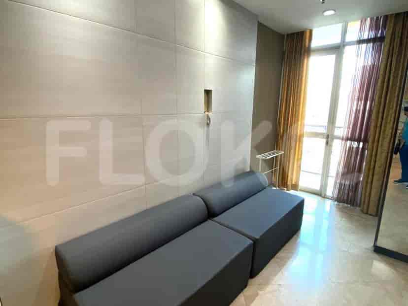 Close-up of the grey sofa in the living area, with a door and window visible.