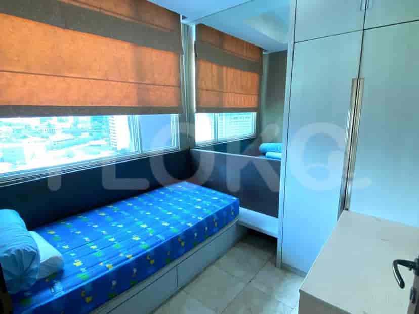Second bedroom with twin bed, study area and built-in storage.