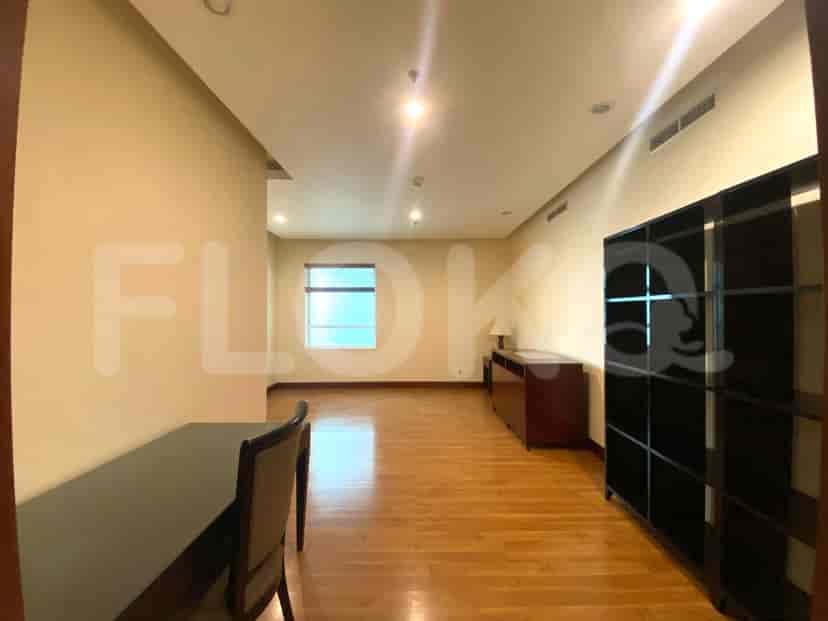 Ruang kantor dengan meja, lantai kayu, dan rak built-in.