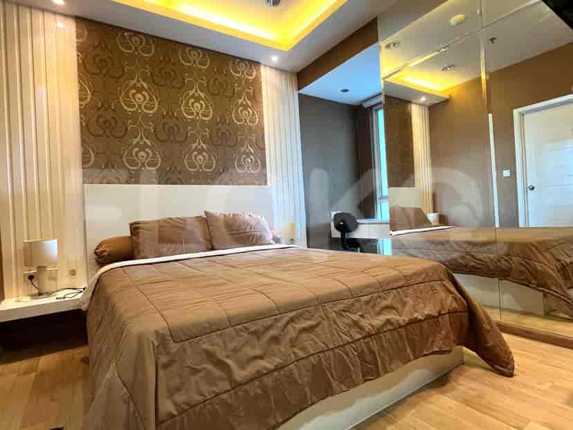 Bedroom with a large bed, mirrored wall, and a cityscape visible from the window.