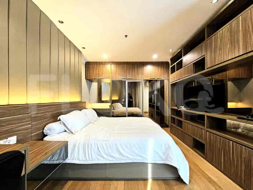 A modern bedroom with wooden paneling, a large bed, and a built-in wardrobe.