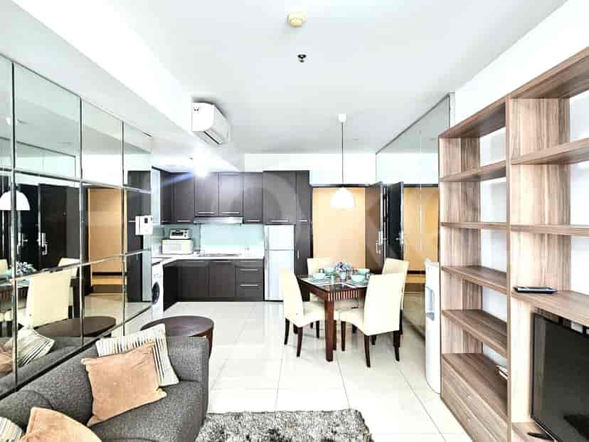Combined living and dining space with kitchen access and large mirrors.