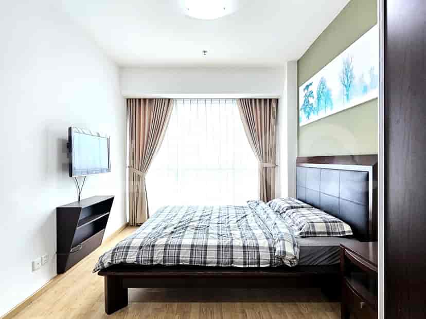 A cozy bedroom with a bed, TV, and curtains.