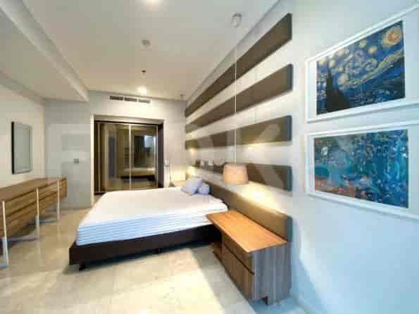 Contemporary bedroom with a large bed and artistic wall decor.