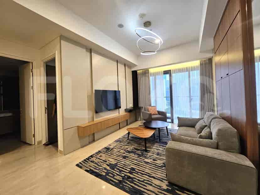 A modern living room featuring an L-shaped grey sofa, a mounted TV, and a sleek coffee table.