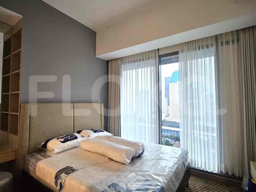 A modern bedroom with a bed, window and curtains.