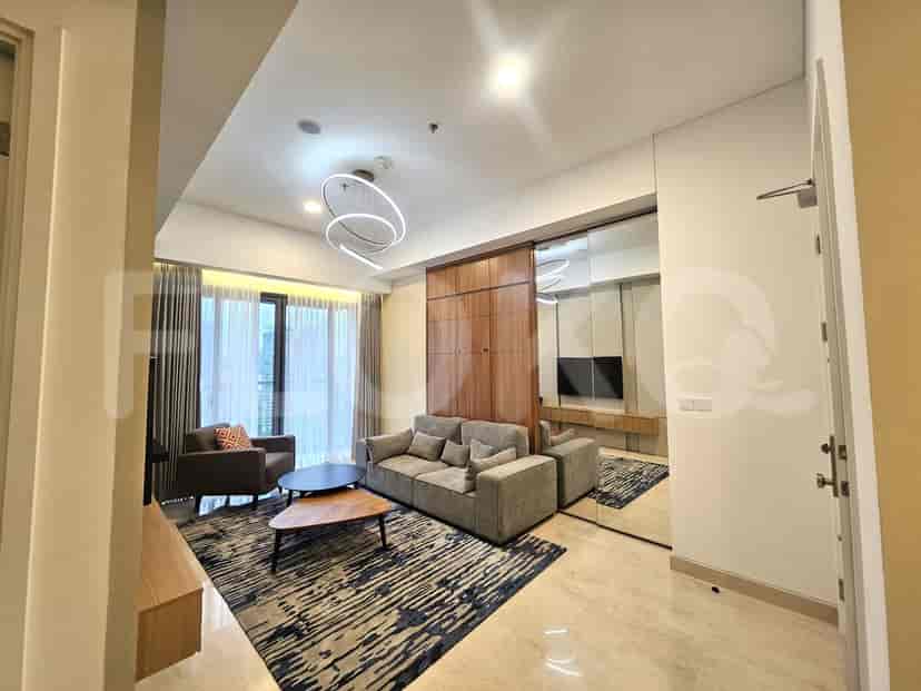 The living room, showing the sofa, mirror wall, and a glimpse of the city outside the windows.
