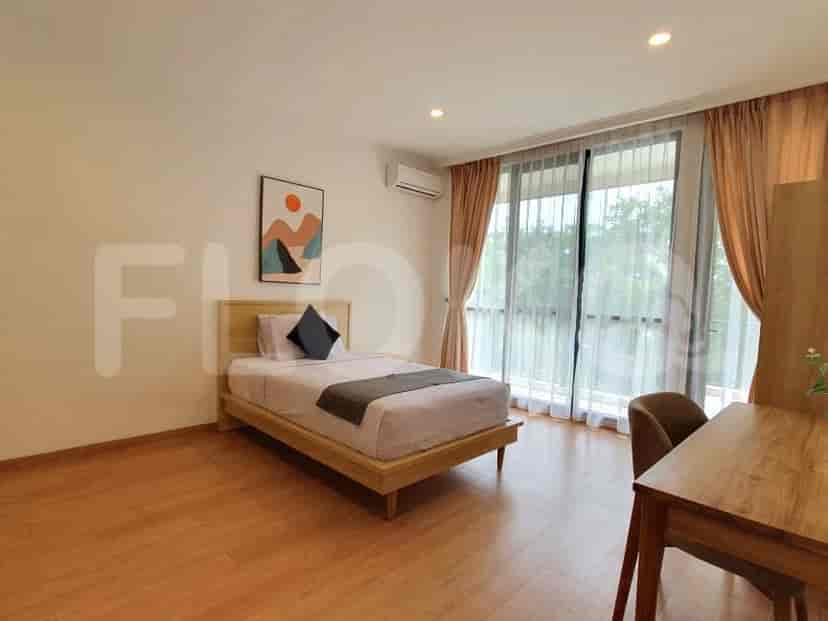 Kamar tidur dengan tempat tidur single, akses balkon, dan meja.