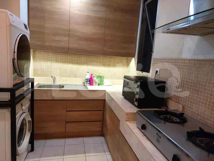 A modern kitchen with wooden cabinets, appliances, and a gas stove.