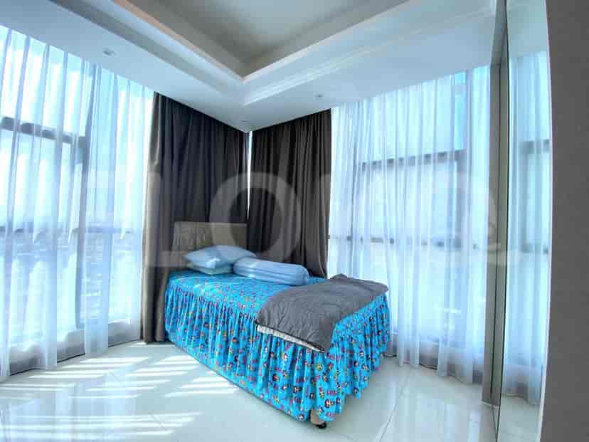 Bedroom with large windows and blue bedding, showcasing a modern and airy aesthetic.