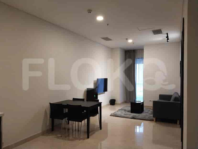 Combined living and dining area with a TV, dining table, and sofa.