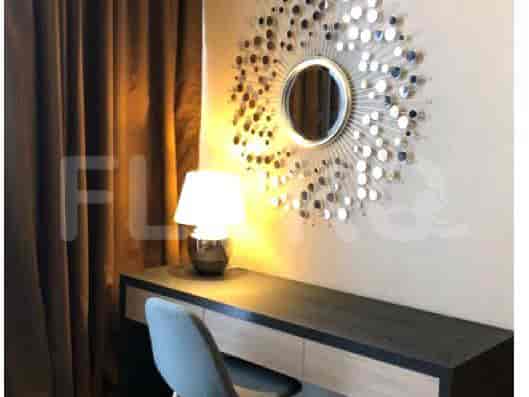 A vanity area with a mirror, desk, and a stool.