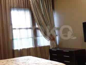 A bedroom featuring a bed, a dresser, and window with curtains.