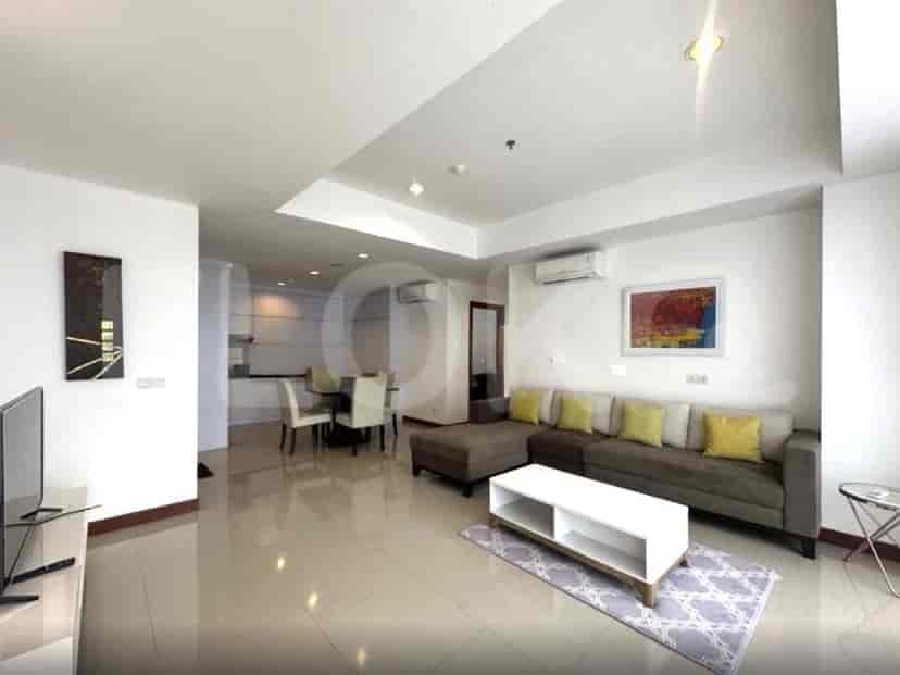 A modern living room with a large sectional sofa, coffee table, and abstract art on the wall.