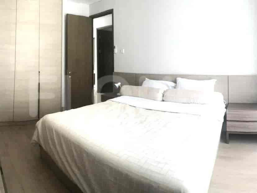 A bedroom with a bed, nightstand, and a large wardrobe.