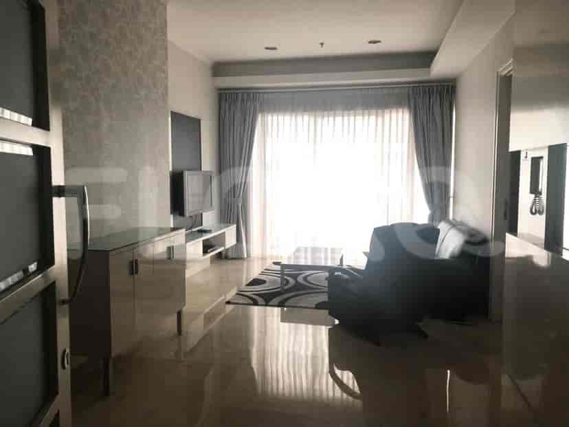 A living room with a large window, sofa, coffee table, and two televisions.