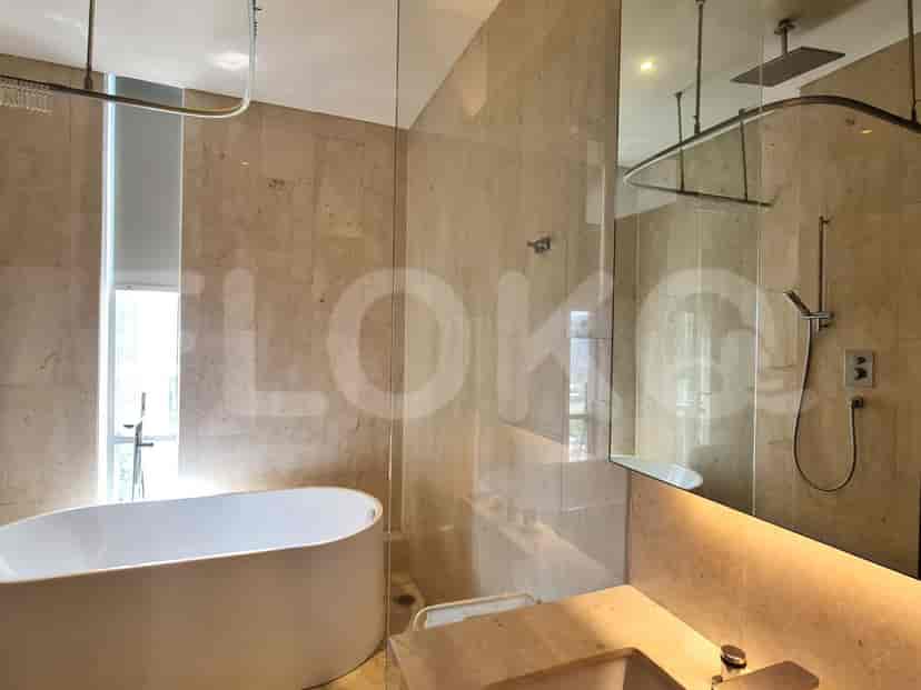 A luxurious bathroom with a freestanding bathtub, marble walls, and a glass-enclosed shower.