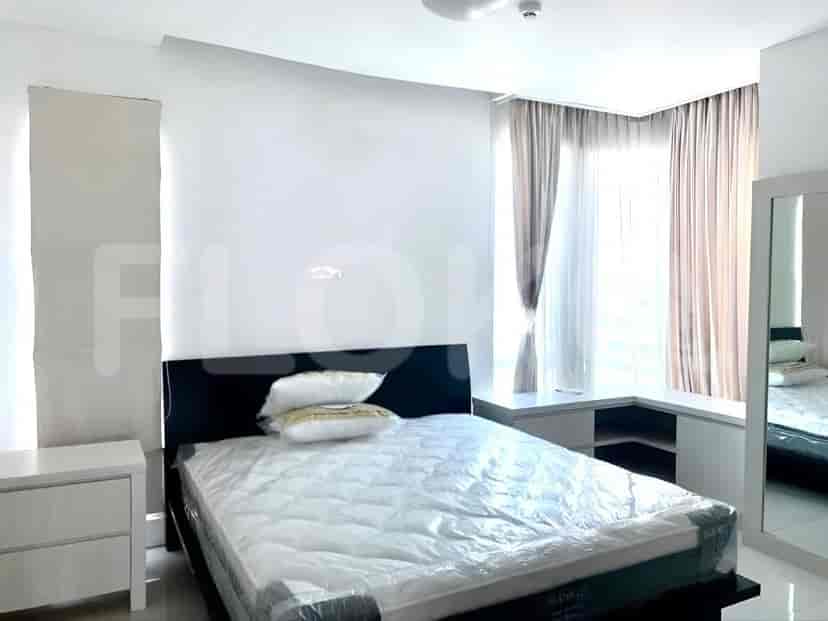 Kamar tidur dengan tempat tidur ukuran queen yang ditutupi plastik pelindung, meja samping tempat tidur, dan tirai.