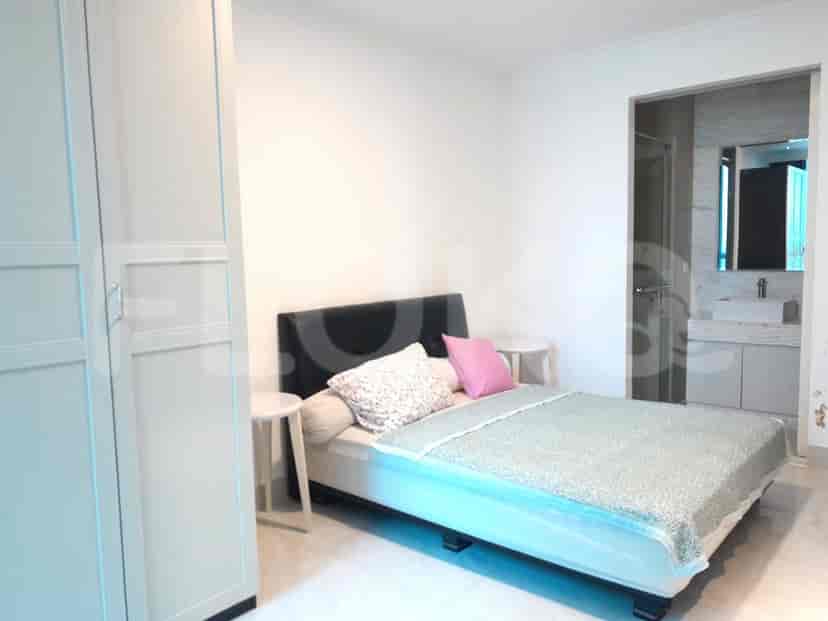 A bedroom with a queen-sized bed, two bedside tables, and a large wardrobe, with a doorway leading to an en-suite bathroom.