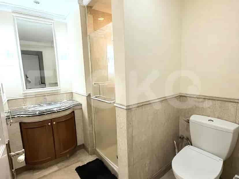 A bathroom with a vanity, sink, glass-enclosed shower, and toilet.