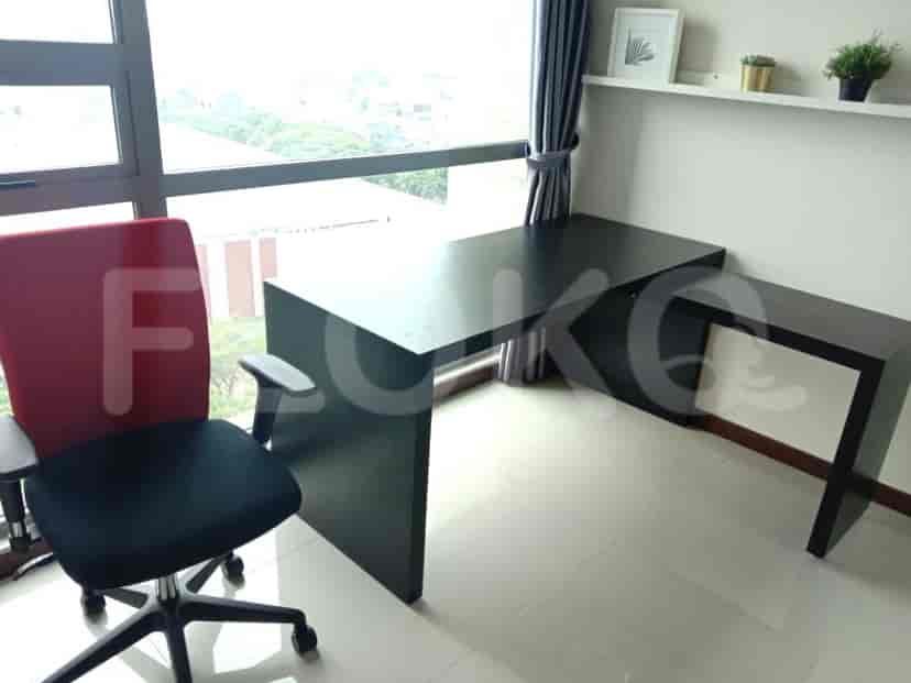 Ruang kantor rumah dengan meja berbentuk L besar dan kursi kantor merah-hitam.