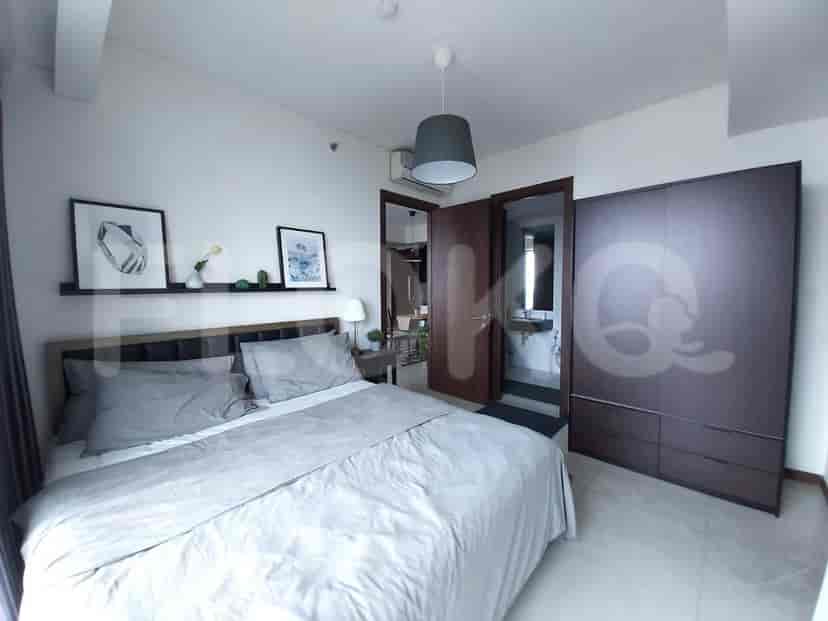 Kamar tidur dengan tempat tidur ukuran queen, meja samping tempat tidur, dan lemari pakaian besar.