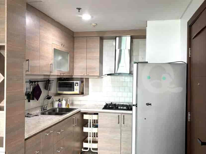 Dapur dengan lemari kayu, kompor, cerobong asap, dan kulkas.