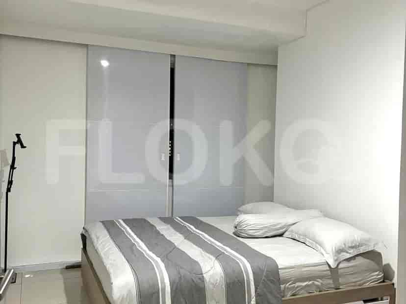 Kamar tidur dengan tempat tidur ukuran queen dan pintu geser.