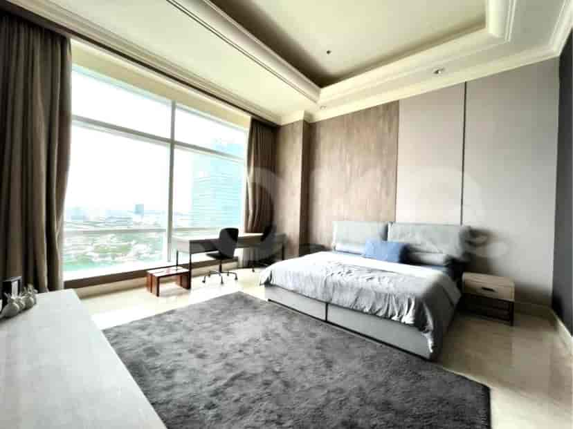 A master bedroom with a king-size bed, a large window, and a desk area.