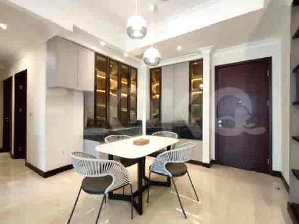 A dining area with a white table, modern chairs, and decorative cabinets.