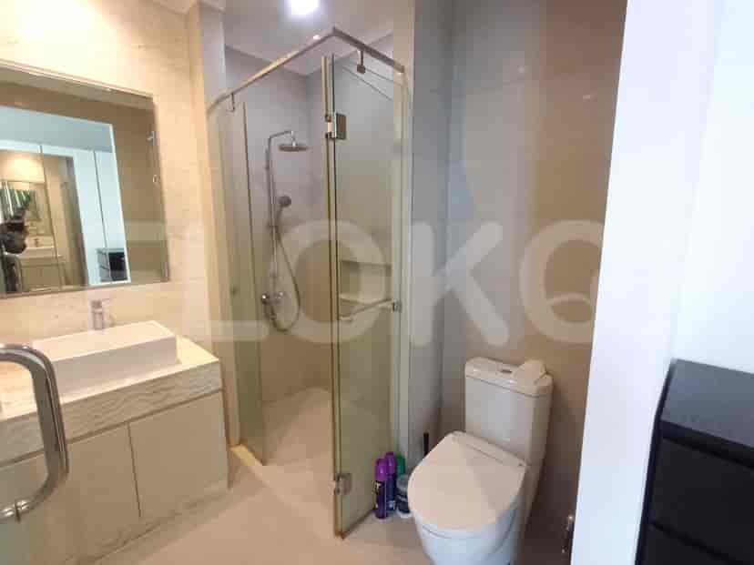 A bathroom with a glass-enclosed shower, a modern toilet, and a vanity with a rectangular sink.