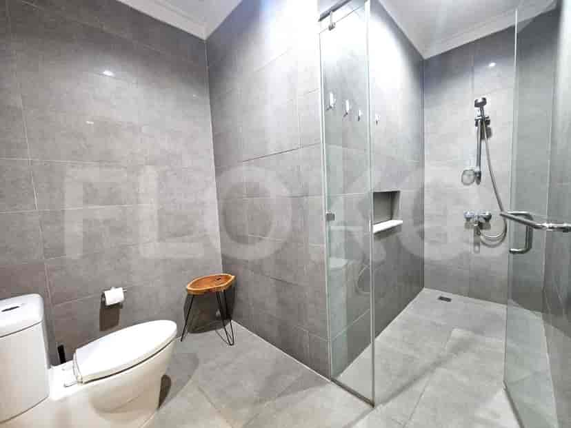 A modern grey-tiled bathroom with a walk-in shower and a wall-mounted toilet.