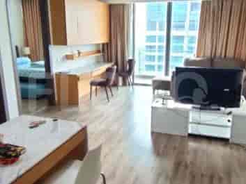 Ruang keluarga yang terang dengan sofa, meja TV, dan jendela besar yang menghadap ke kota.