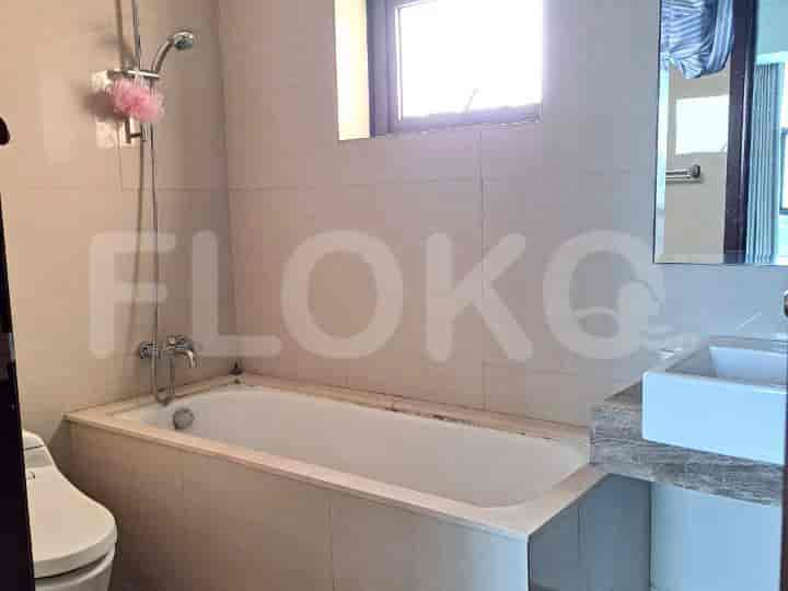 A bathroom with a bathtub, toilet, and a sink with a marble countertop.