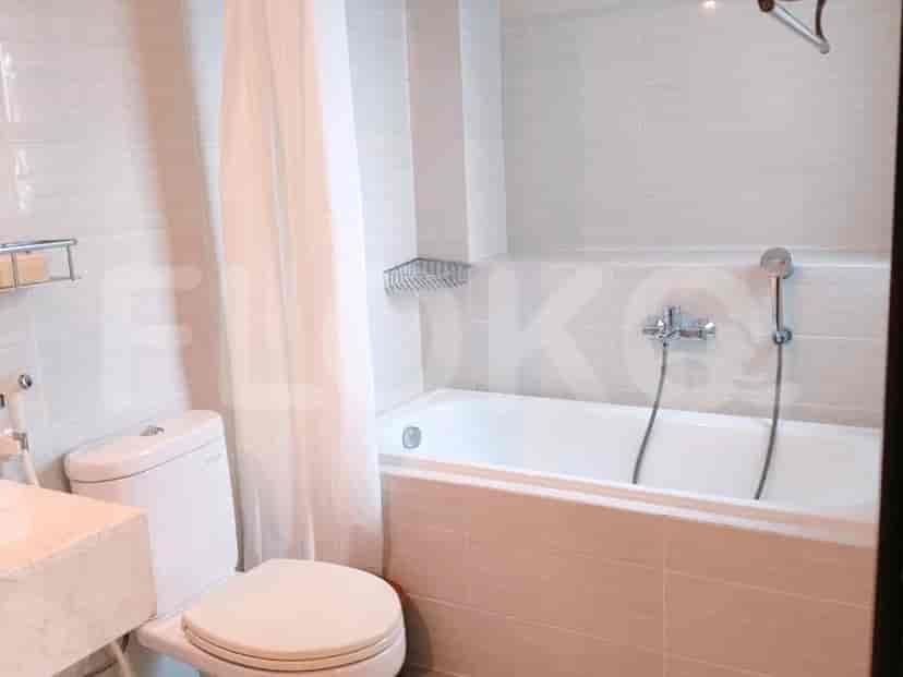 A clean bathroom with a bathtub, toilet, and tiled walls.