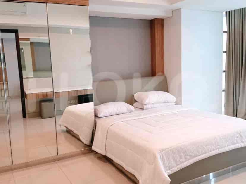 A bedroom with a white bed, large mirrored wardrobe, and soft lighting.