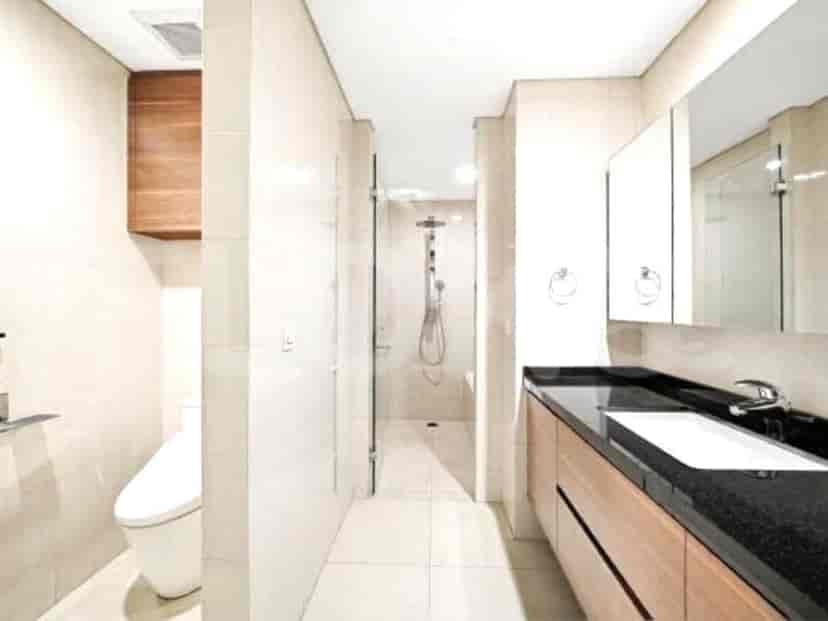 A modern bathroom with a vanity, toilet, and a glass-enclosed shower.