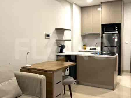 Dapur ringkas dengan peralatan modern, termasuk kulkas, microwave, dan kompor induksi.