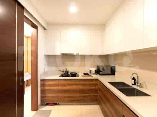 A modern, compact kitchen with wooden cabinets and white countertops.