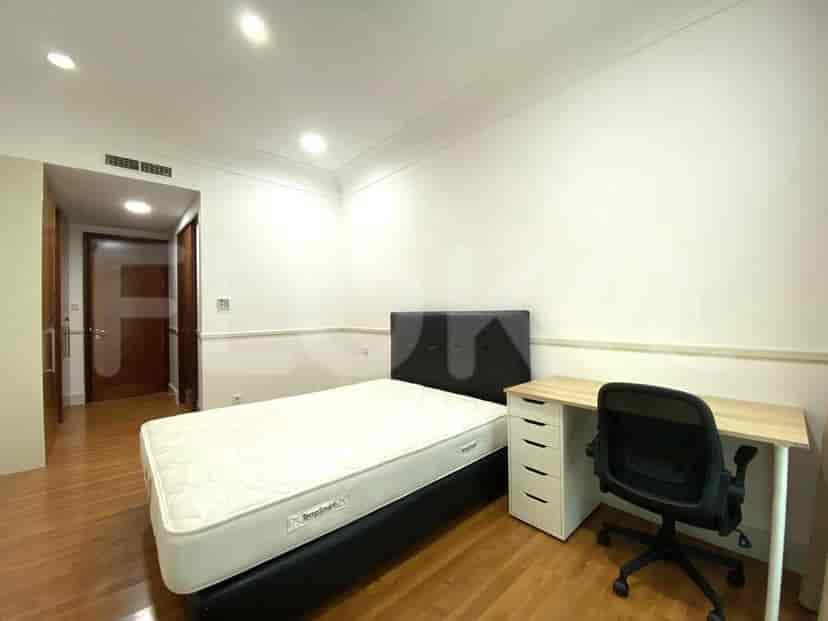 A bedroom with a single bed, a desk, and a chair.