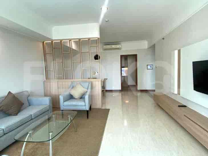 A modern living room featuring a light grey sofa, an armchair, a glass coffee table, and a decorative partition.