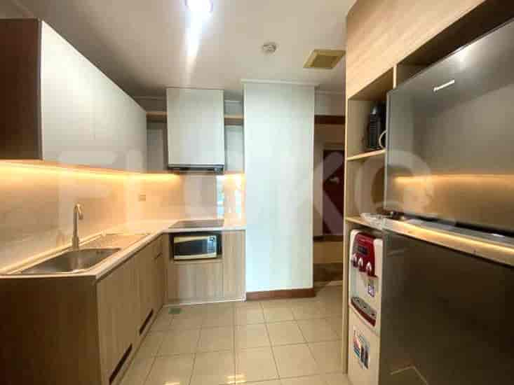 A modern kitchen with light wood cabinetry, a stainless steel sink, and integrated appliances.