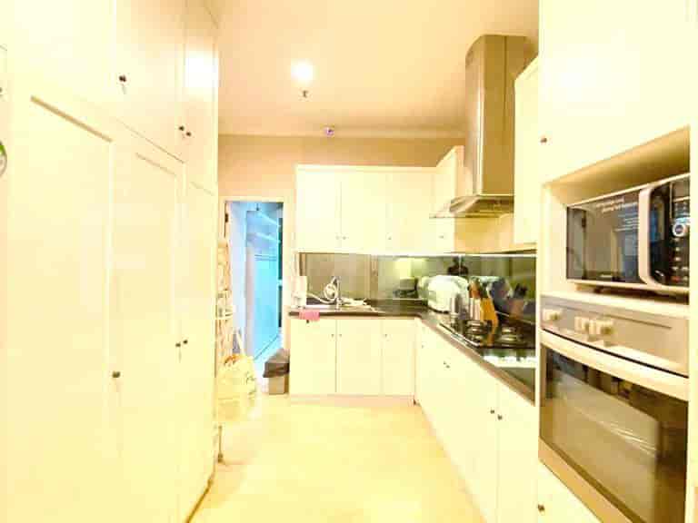 A sleek, modern kitchen with white cabinetry, stainless steel appliances, and a granite countertop.
