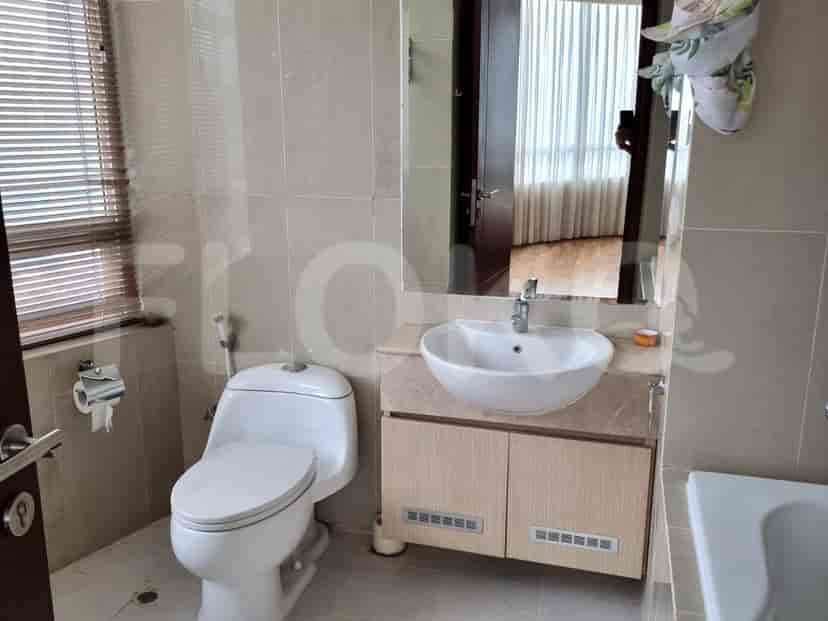 A bathroom with a toilet, a vessel sink, and a vanity with storage.