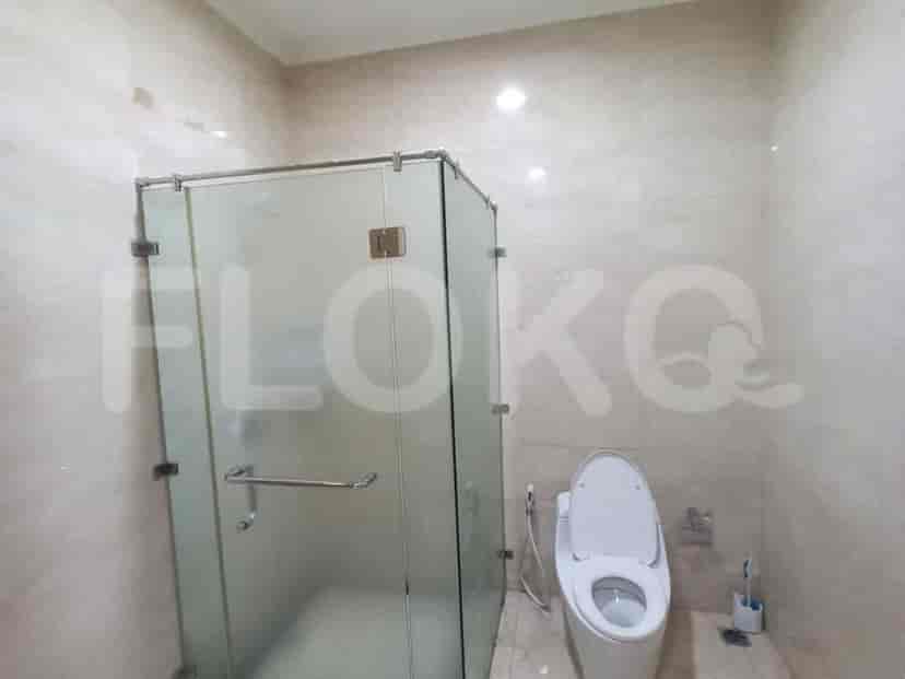 Kamar mandi dengan toilet modern dan bilik shower kaca.