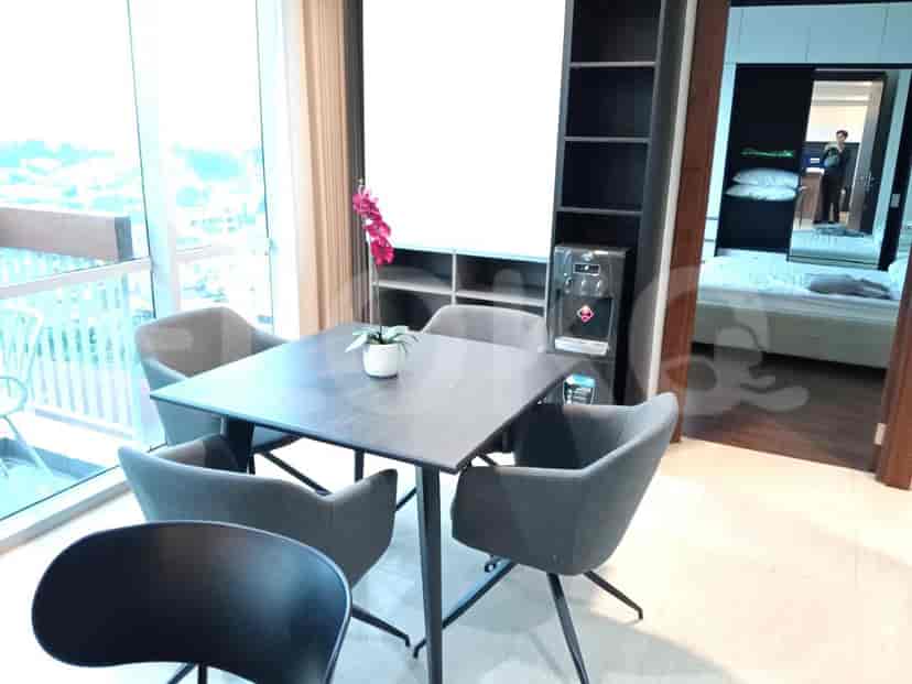 A dining area with a square table and four chairs, adjacent to a tall shelving unit with a water dispenser.