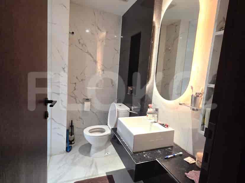 Kamar mandi mewah dengan dinding marmer, wastafel modern, dan toilet.